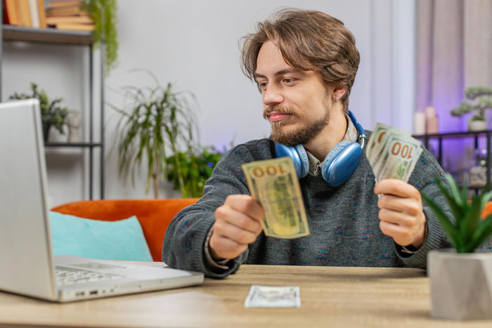 Young man holding hundred dollar bills representing wealthy boyfriend finances Young man holding hundred dollar bills representing wealthy boyfriend finances