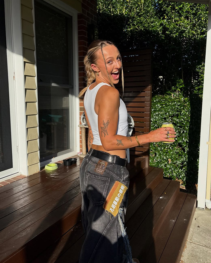 Casual photo of bridesmaid with tattoos outside in sunlight