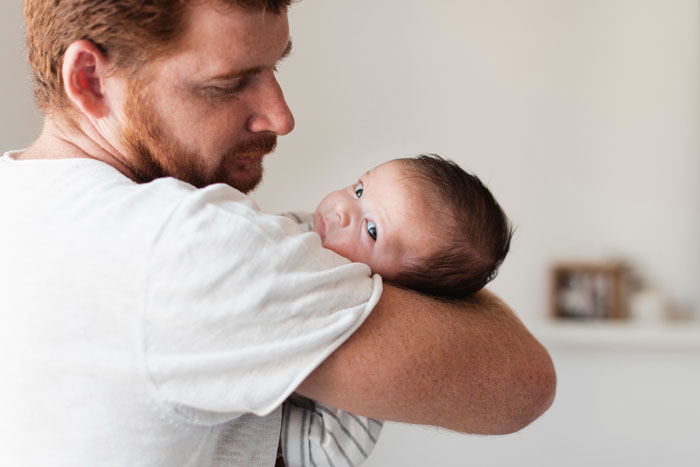 Father holding newborn baby with loving care Father holding newborn baby with loving care