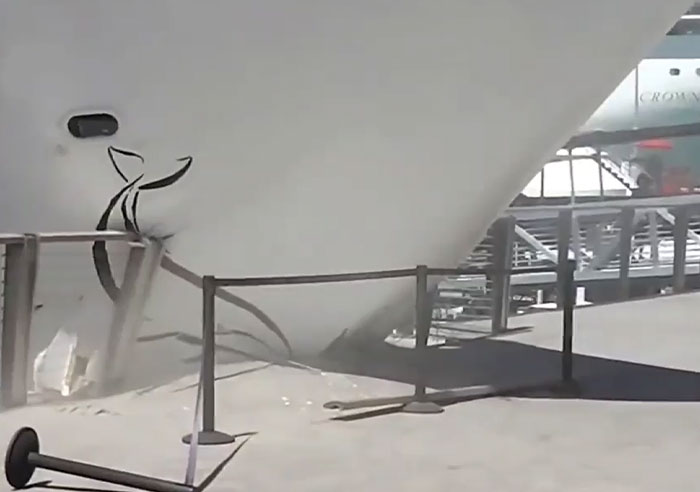 A cruise ship bow with damage and a broken barrier from a catastrophic machinery failure.