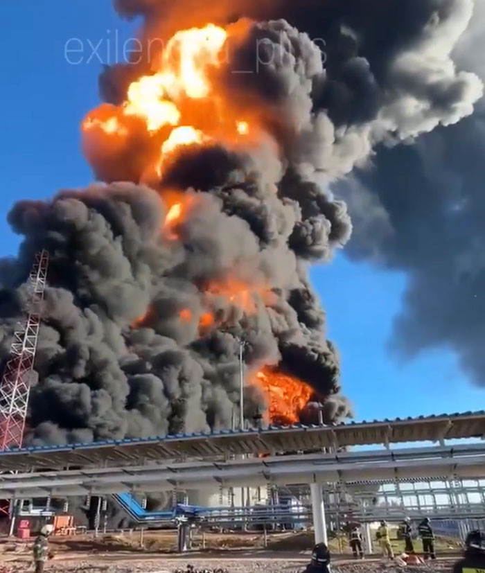 Catastrophically failed machinery with massive flames and thick black smoke billowing from an industrial facility.