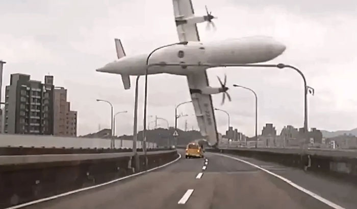 A passenger plane nose-dives into a highway, with cars driving beneath, a catastrophic machinery failure.
