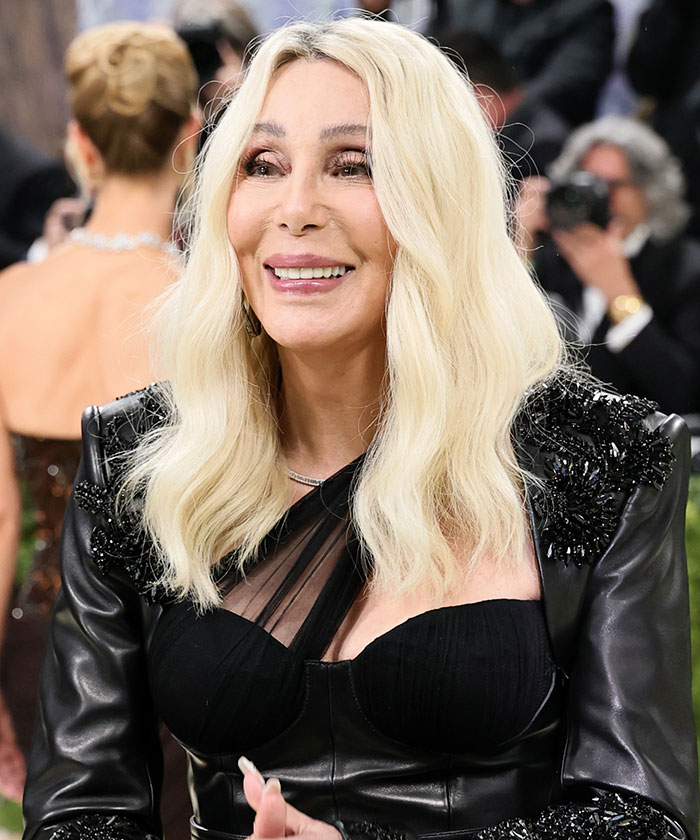 Cher at the Met Gala 2026, showcasing a look that highlights recent plastic surgery. Her blonde hair frames her face, revealing a confident smile.
