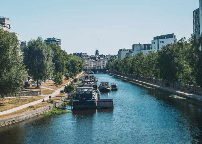 Scenic river canal in France with boats and buildings on a sunny day