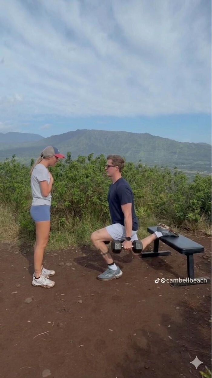 Woman watching a man doing lunges with a dumbbell on a mountain. Proposal pic ready for edits.