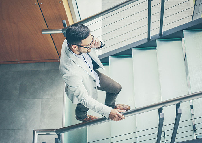 Man talking on phone walking up stairs reflecting on closest and creepiest encounters with passing away