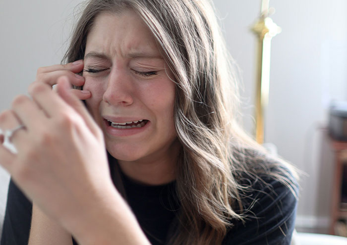 Woman crying on phone after closest and creepiest passing away encounter