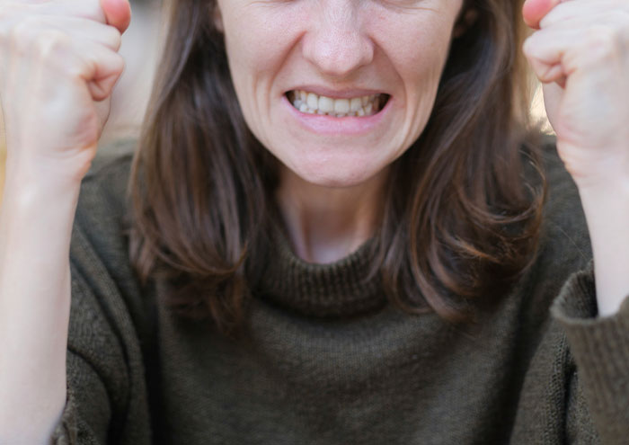 Person clenching fists in frustration during closest and creepiest passing away encounters