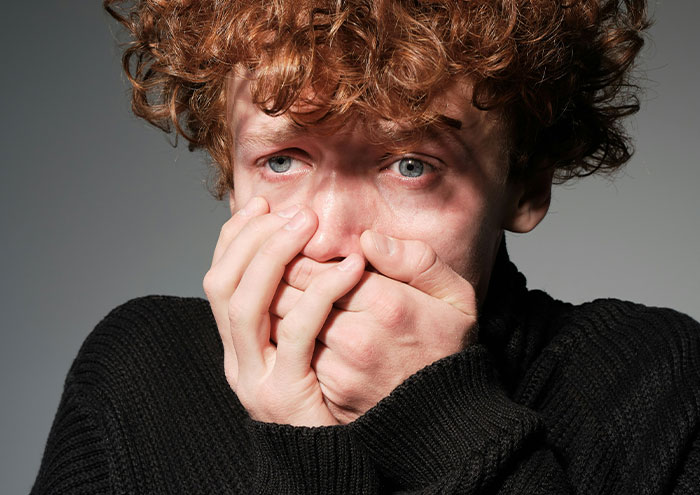 Scared young man covering mouth experiencing closest and creepiest passing away moments