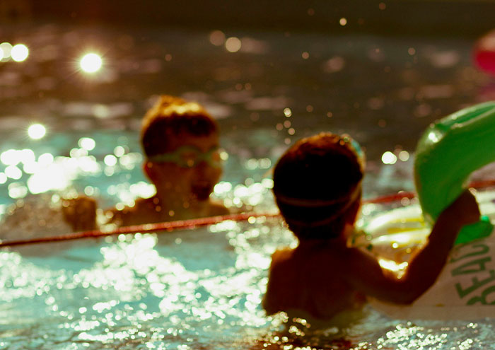 Children splashing in swimming pool symbolizing carefree moments before passing away