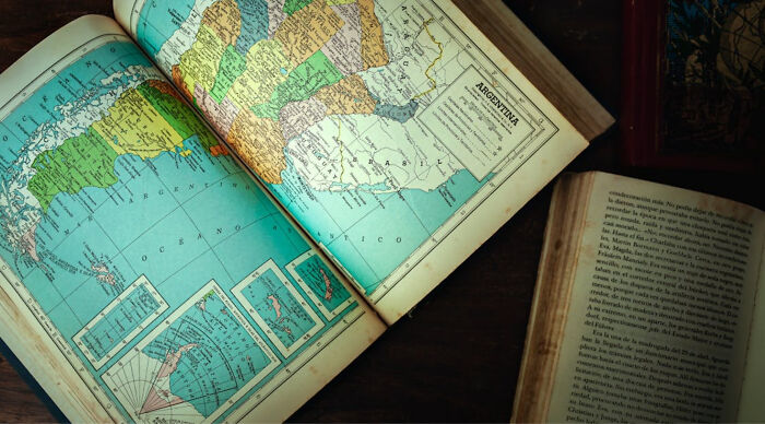 Open old book displaying a detailed map of South America, with Argentina and Brasil labeled. Discover countries.