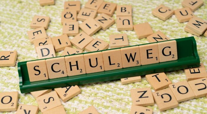 Scrabble tiles arranged with mixed letters for a country name unscrambling game Scrabble tiles arranged with mixed letters for a country name unscrambling game