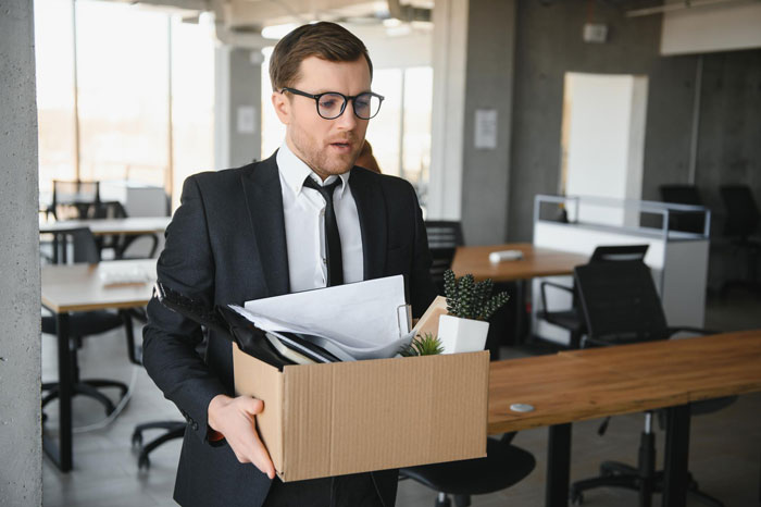 Man carrying a box of belongings, looking solemn. Represents an office food thief getting fired. Man carrying a box of belongings, looking solemn. Represents an office food thief getting fired.
