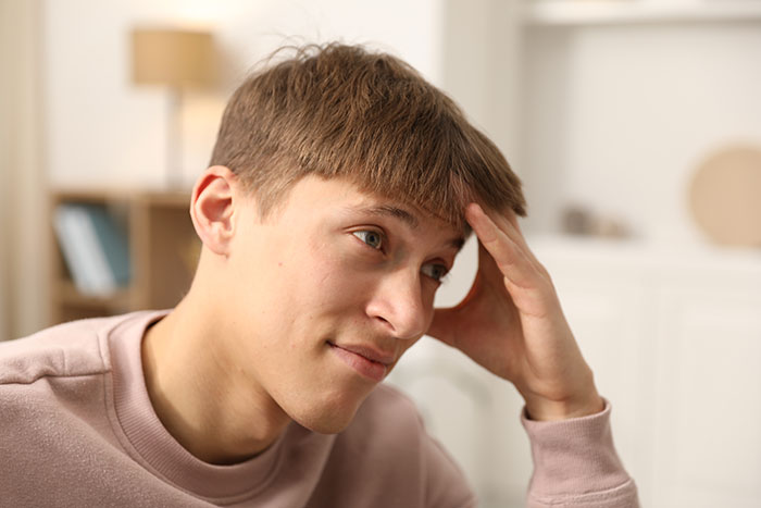 Young man looking thoughtful and uneasy reflecting on creepy things women have done