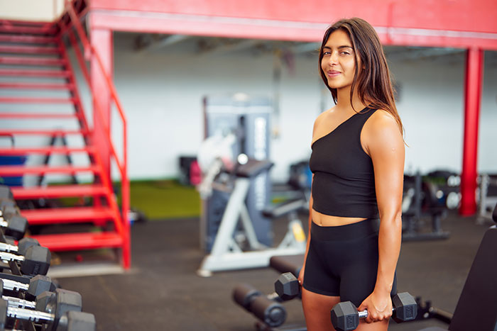 Woman holding dumbbells in gym sharing creepy things women have done
