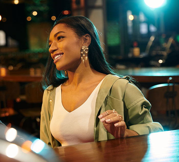 Woman in bar setting listening to creepy things women have done to men