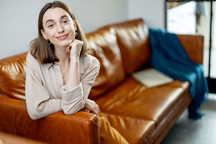 Woman smiling on leather couch sharing creepy things women do to men
