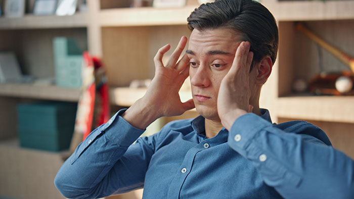 Stressed man holding head upset about creepy things women have done