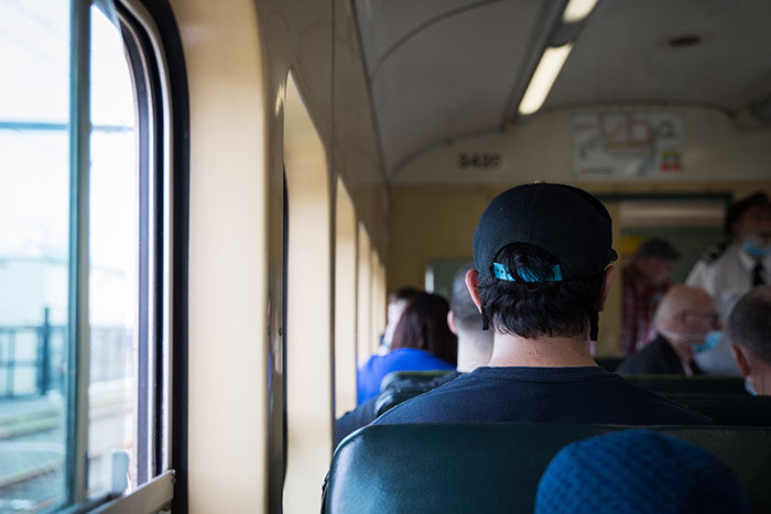 Men sitting on a train, illustrating creepy encounters shared by men