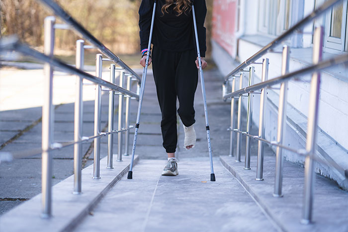 Person with cast walking on crutches outdoors showing creepy experiences