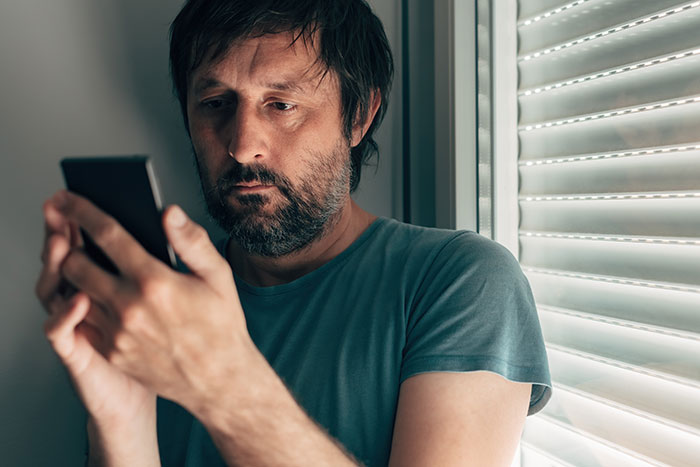 Man looking seriously at phone, creepy things women have done