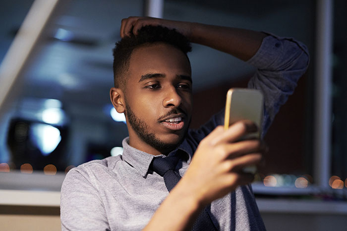 Man looking at phone frustrated at night, creepy things women have done