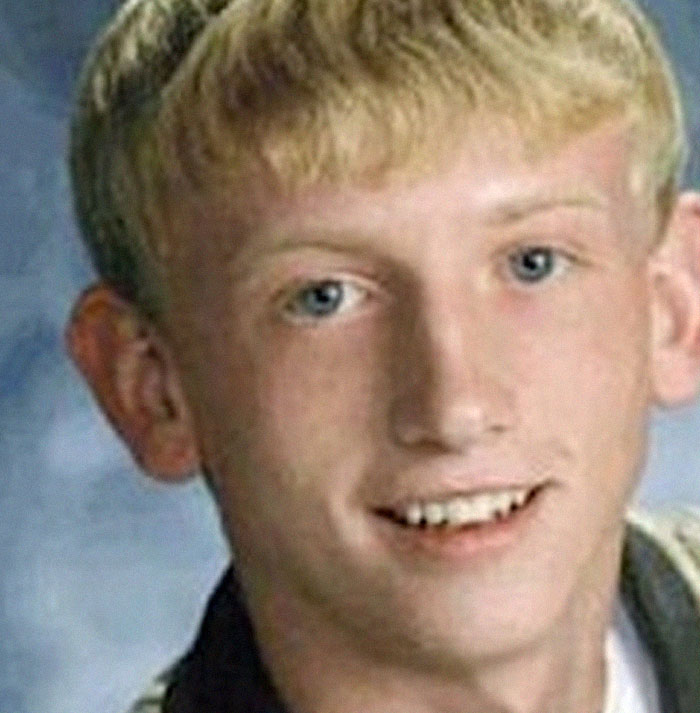 Close-up of a smiling young man with blond hair and blue eyes