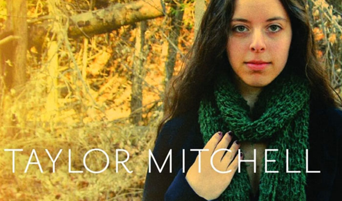 Young woman with dark hair and green scarf outdoors in a forest setting