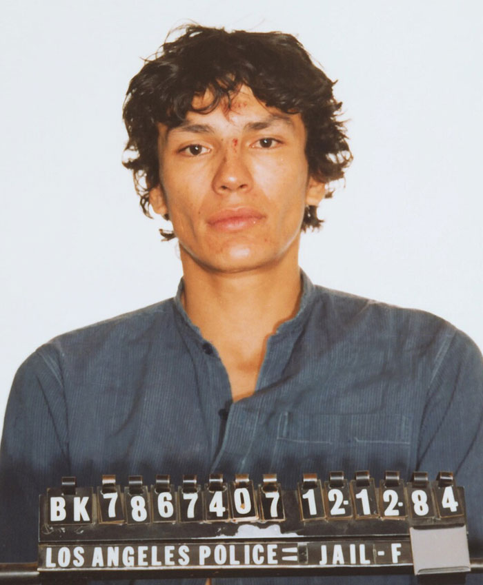 Color mugshot of a young serial killer in police custody