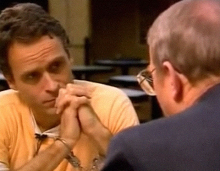 Serial killer in handcuffs during an intense interrogation scene