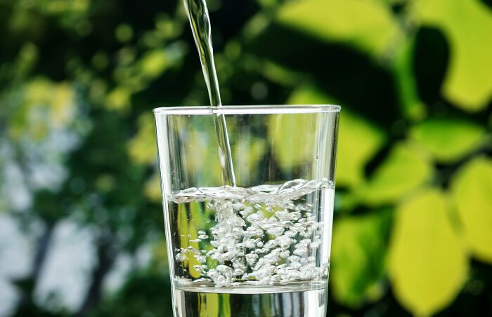 Glass of water being filled symbolizing water scarcity as an inevitable issue