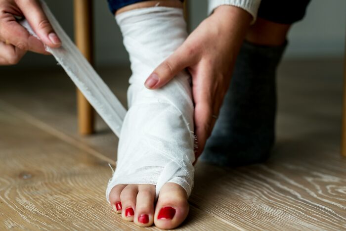 Close-up of foot being wrapped with medical bandage for injury