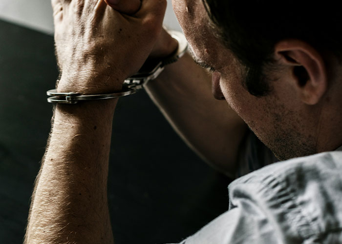 Man in handcuffs revealing dark secrets accidentally discovered