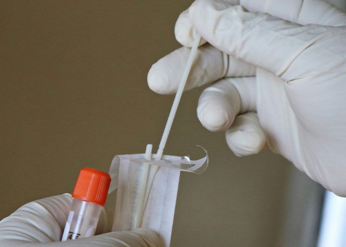 Healthcare worker holding a swab for COVID-19 testing procedure