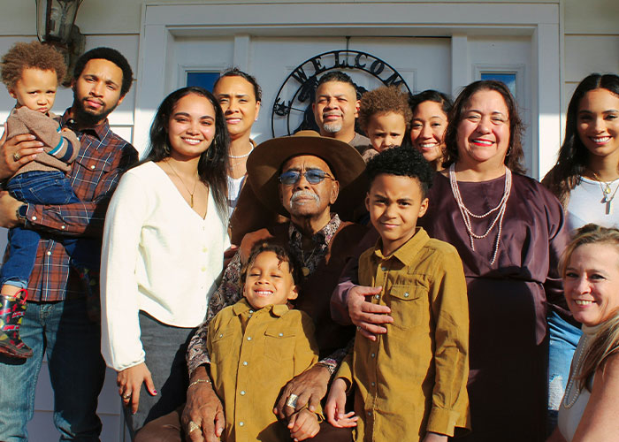 Large happy multigenerational family posing outdoors at home entrance