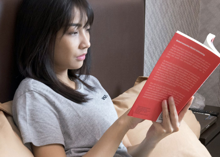 Woman reading book focused on dark secrets discovery