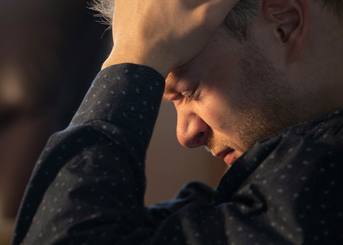 Man stressed holding head showing dark secrets revealed