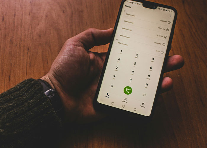 Hand holding phone dialing showing calls related to dark secrets