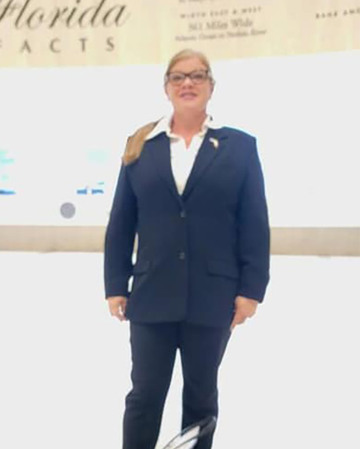 Beloved Christian mom in dark suit standing indoors Beloved Christian mom in dark suit standing indoors