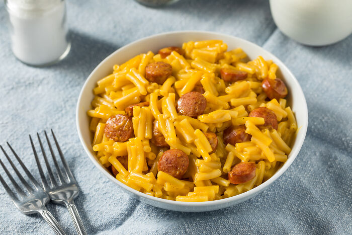 Bowl of cheesy macaroni with sausage slices as a poverty meals option