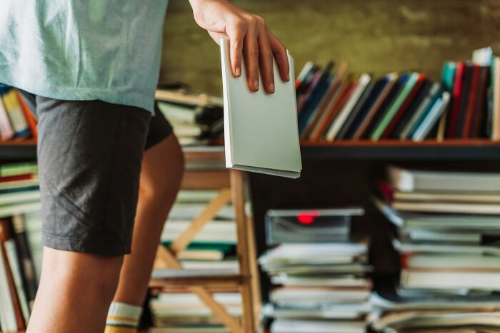 Person browsing books highlighting peace over paycheck lifestyle changes