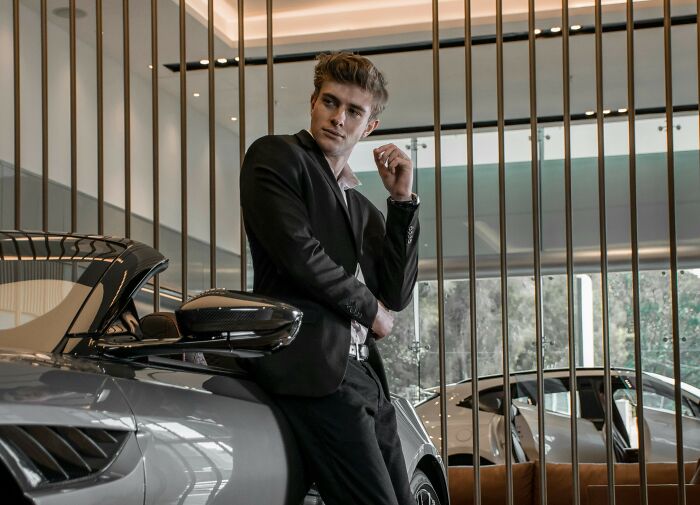 Man in suit leaning on car with confident pose scary inevitable moments