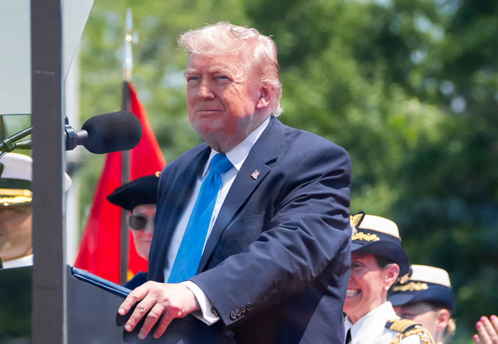 Man in suit speaking at podium during public event