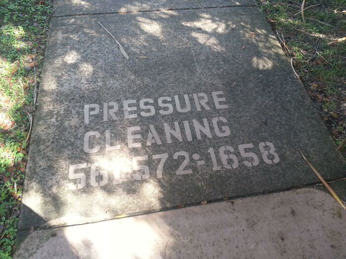 Pressure cleaning advertisement revealed on a cleaned concrete sidewalk