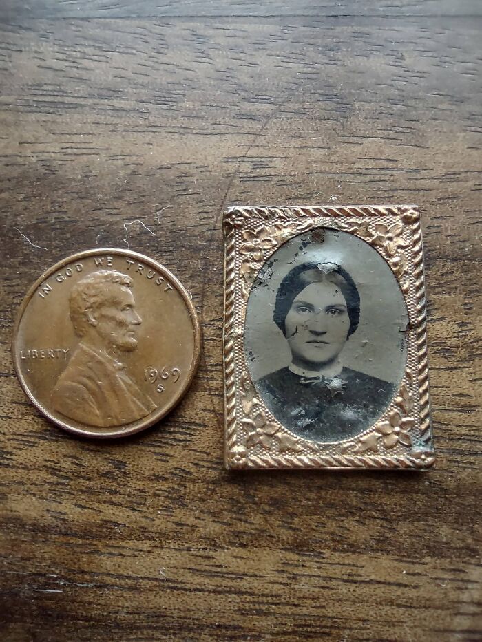 A US penny next to an early American miniature photograph of a woman in an ornate gold frame, showing historic pieces people collected.