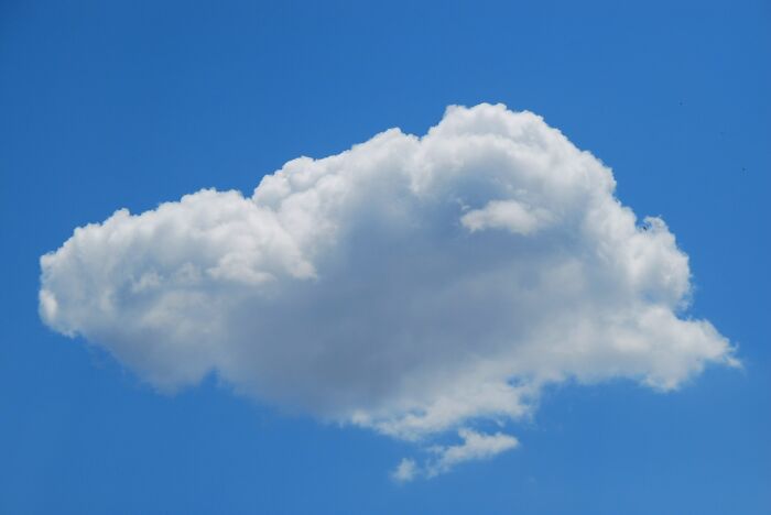 White fluffy cloud floating in bright blue sky