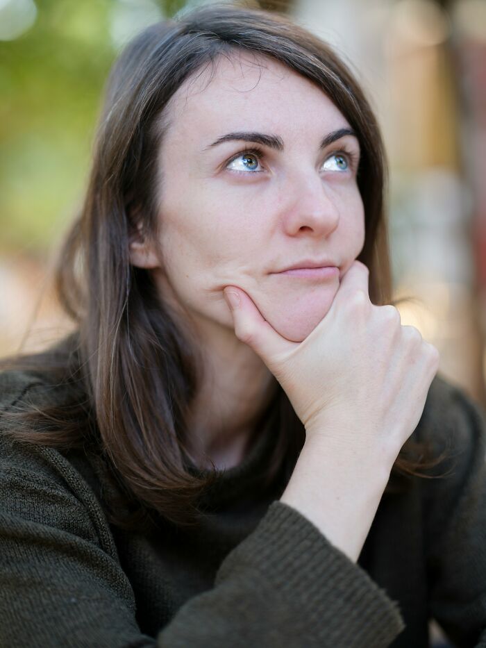 Woman resting chin on hand while looking thoughtfully into distance