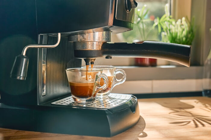 Espresso machine making coffee, saving money on daily coffee runs. Expensive habits that save money are visible.