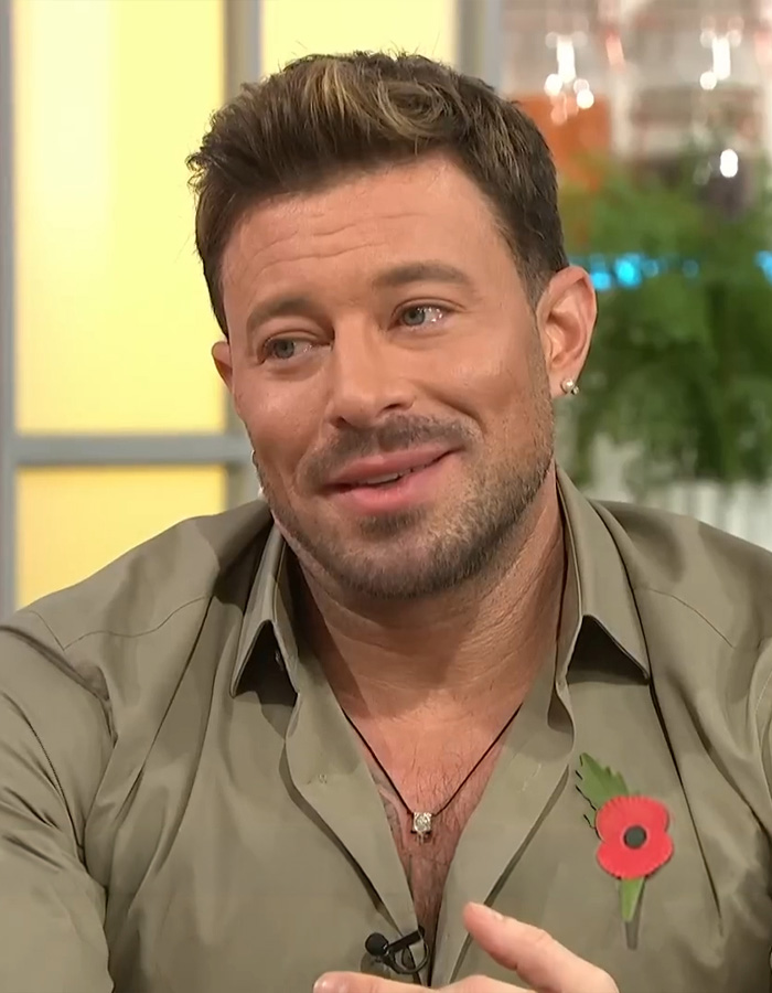 Smiling man with a short beard and poppy pin discussing coming out gay while married