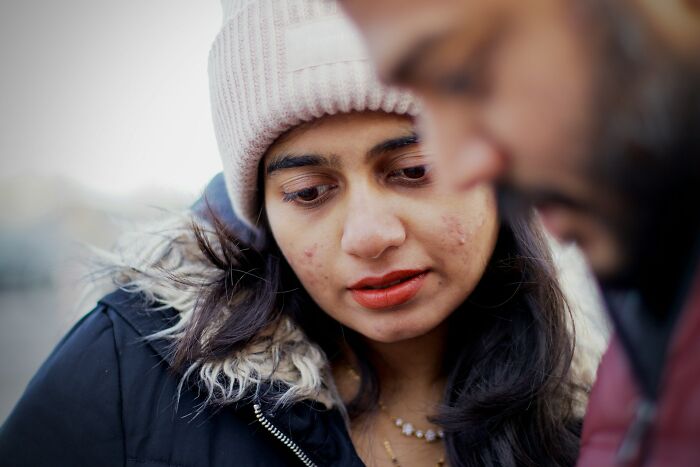 Woman in winter coat and hat looking down during a difficult situationship talk